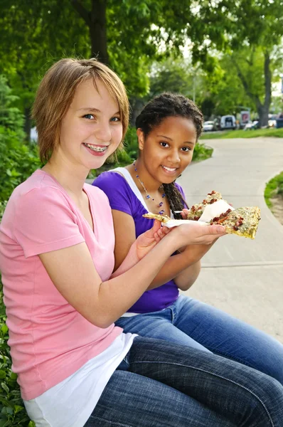 两个十几岁的少女坐在和吃披萨 — 图库照片