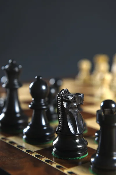 Czarne figury szachowe na pokładzie — Zdjęcie stockowe