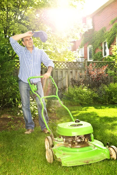 男の熱い夏の日の芝生を刈っている間の休憩を取って — ストック写真