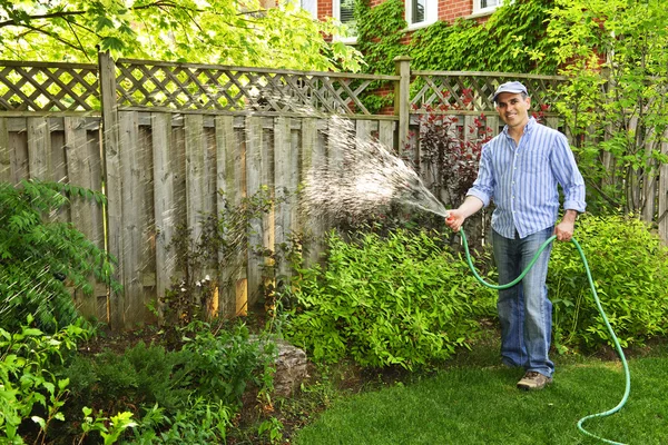 Adam bahçeyi suluyor. — Stok fotoğraf