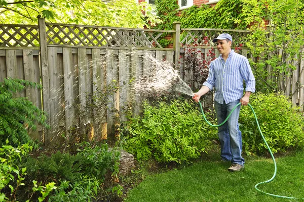 Homem rega jardim — Fotografia de Stock