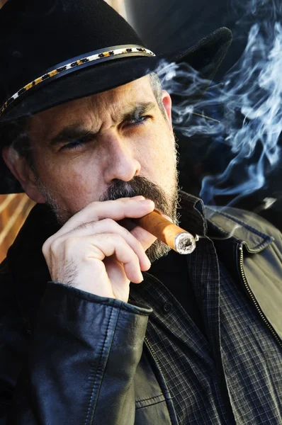 カウボーイ ハット喫煙葉巻でひげを持つ男 — ストック写真