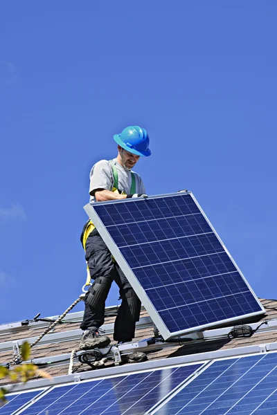 代替エネルギー太陽光発電太陽電池パネルをインストールする屋根の上の男 ストックフォト