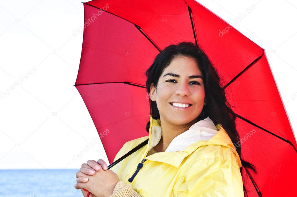 Beautiful young woman in raincoat with umbrella