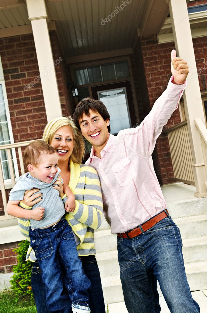 Young excited family celebrating in front of new home