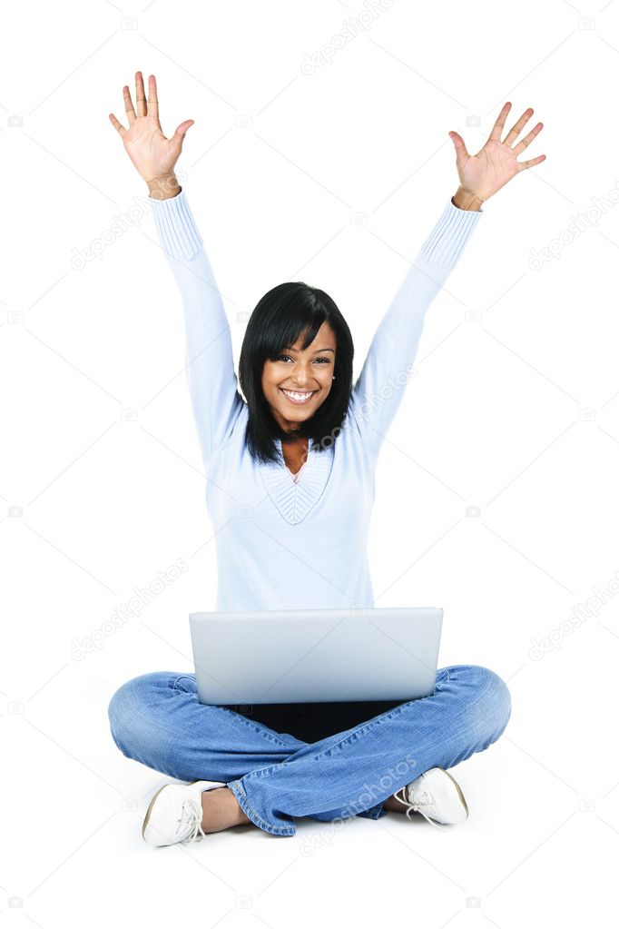 Happy black woman with arms raised and computer isolated on white background