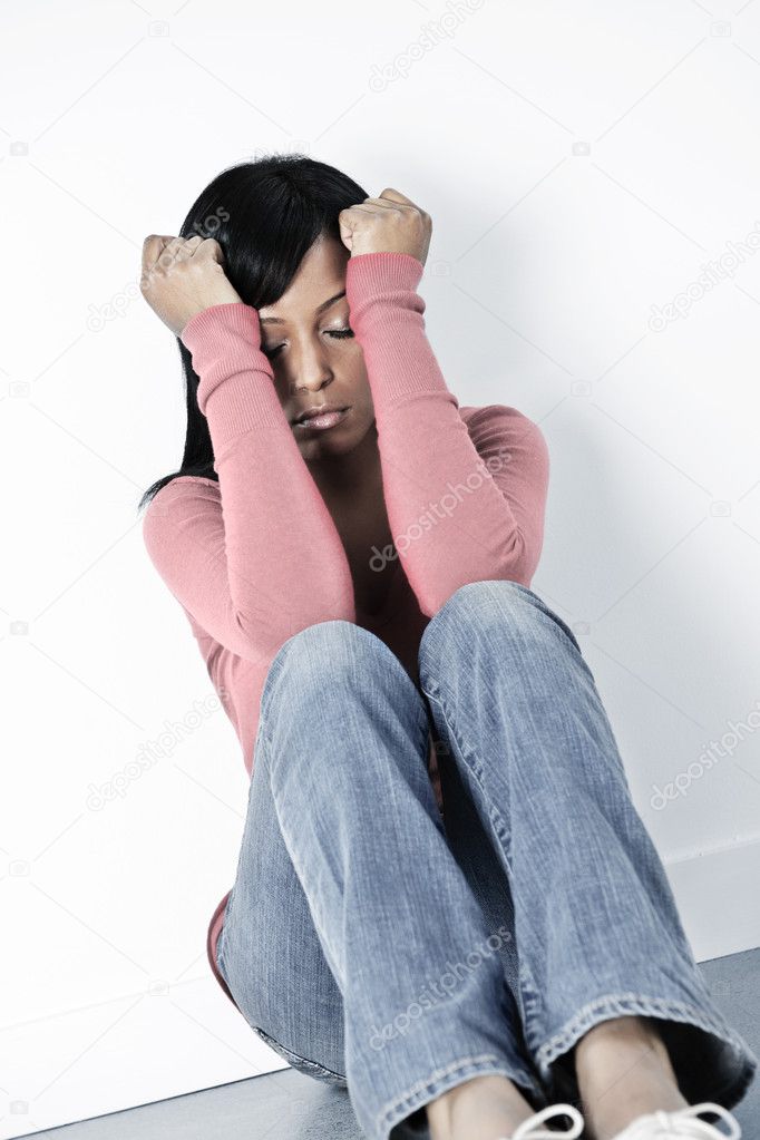 Depressed woman sitting on floor