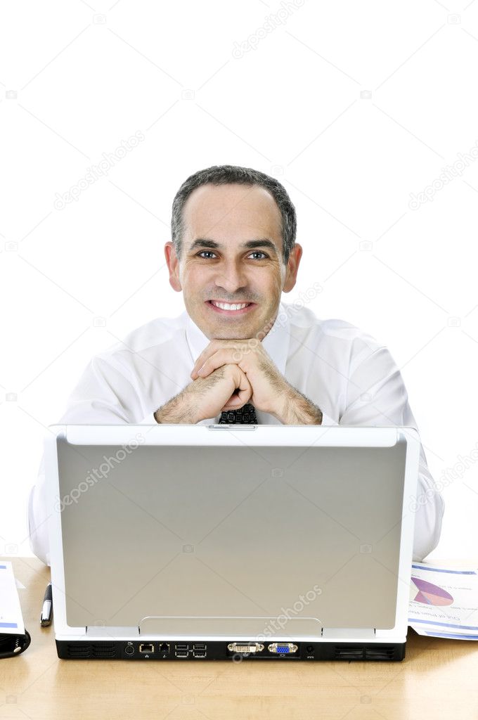 Happy businessman sitting at his desk isolated on white background