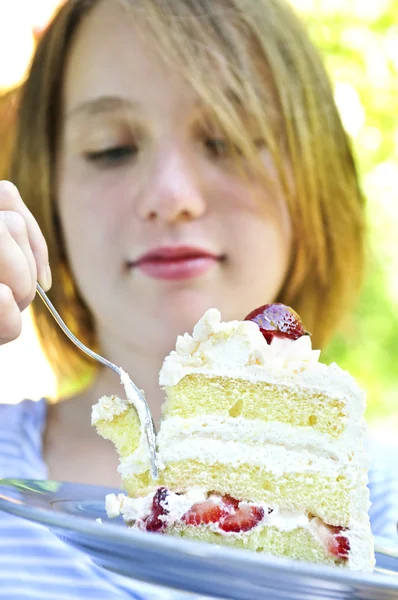 十几岁的女孩吃了一块草莓蛋糕 — 图库照片