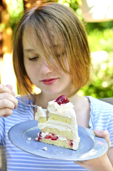 イチゴのケーキの部分を食べて 代の少女 — ストック写真