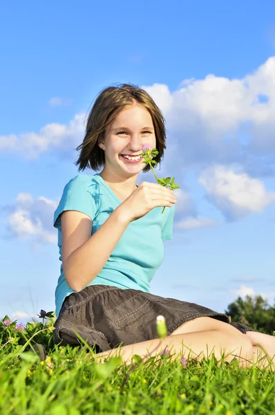 Młoda dziewczyna siedzi na trawie — Zdjęcie stockowe