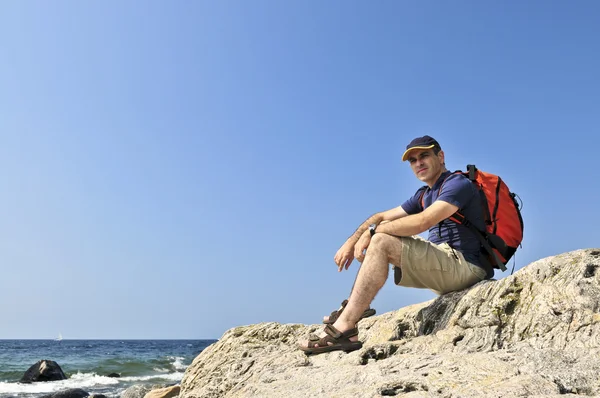 坐在一块岩石上的登山者 — 图库照片
