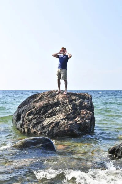 stock image Man stranded on a rock in ocean