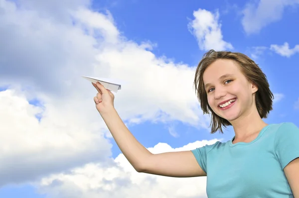 Молодая девушка держит бумажный самолет — стоковое фото
