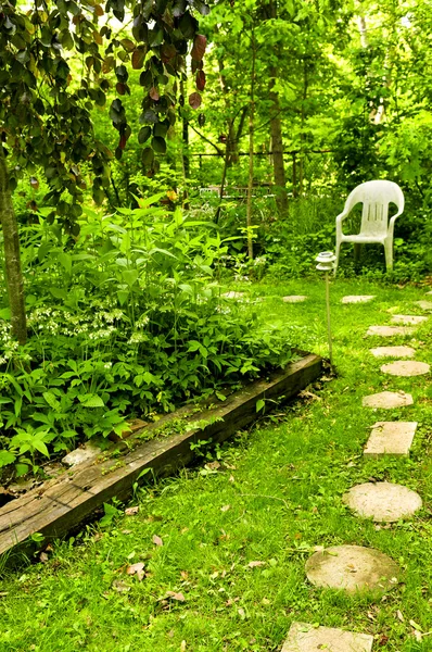 緑豊かな庭園で隔離されたコーナーにつながる飛石のパス — ストック写真