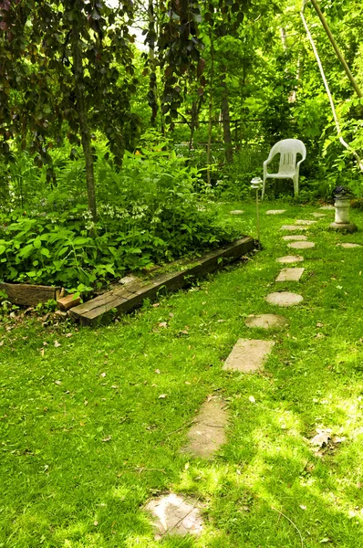 緑豊かな庭園で隔離されたコーナーにつながる飛石のパス — ストック写真