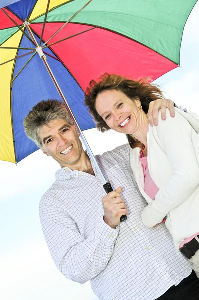 Счастливая зрелая пара с зонтиком — стоковое фото