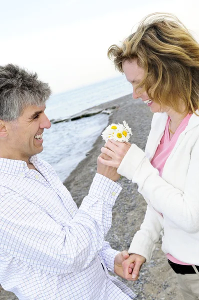 Mature romantic couple with flowers — Stock Photo, Image