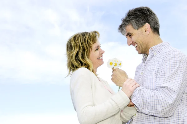 Starší romantický pár s květinami — Stock fotografie