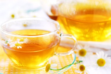çay fincanı ve bitkisel papatya çayı ile bir çaydanlık