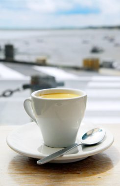 Cup of coffee on a cafe patio table clipart