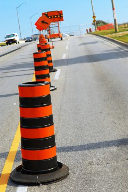 Road construction signs and cones on city street clipart