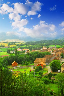 Rural landscape with hills and a small village in eastern France clipart