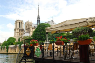Restaurant on a boat on river Seine with the view of Notre Dame de Paris Cathedral in Paris France clipart