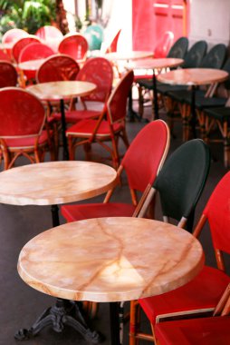 Colorful tables and chairs in sidewalk cafe. Paris, France. clipart