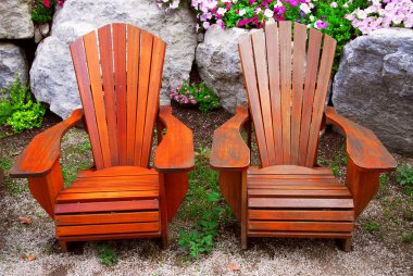 Two solid wood patio chairs and natural stone landscaping clipart