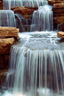 Beautiful cascading waterfall over natural rocks, landscaping element