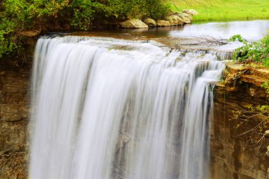 Beautiful waterfall in wilderness at summer time clipart