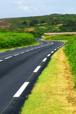 Winding road along the ocean coast in Brittany, France clipart