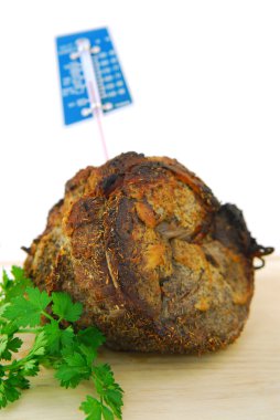 Beef roast just out of the oven with a meat thermometer clipart