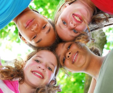 Faces of four happy young girls shot from below clipart