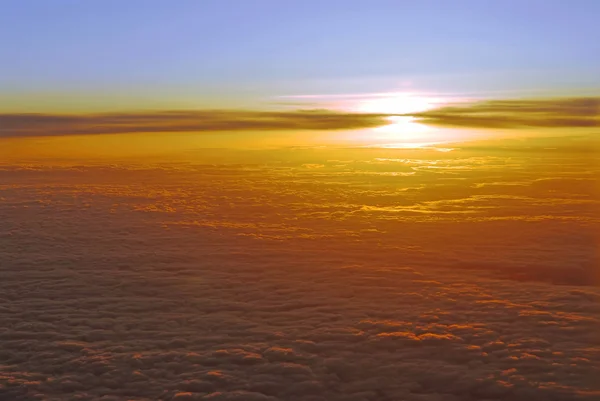 从飞机窗上俯瞰云层上方日落的壮观景象 — 图库照片