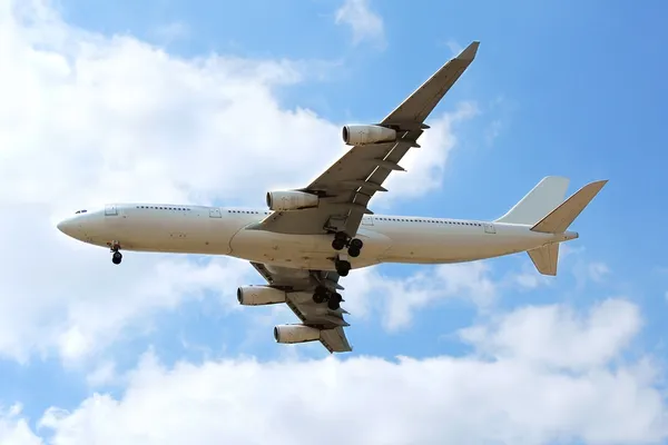 Bulutlar Hiçbir Logoları Ile Mavi Gökyüzünde Uçan Uçak — Stok fotoğraf