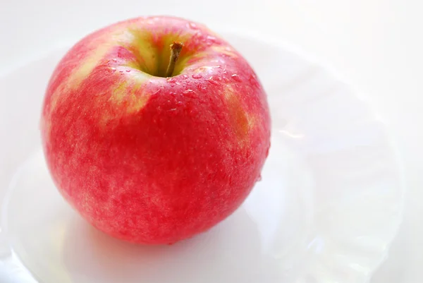 Rode appel op een bord — Stockfoto