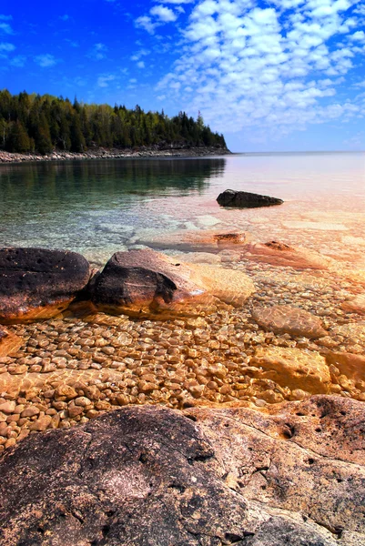 Vacker Utsikt Stenig Strand Med Klart Vatten Och Gyllene Reflektioner — Stockfoto