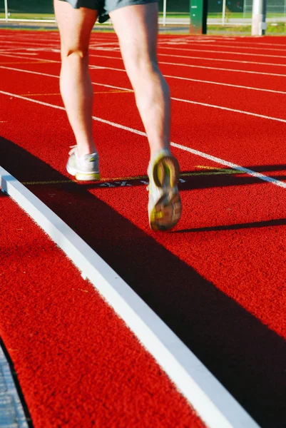 Kırmızı Bir Yarış Pisti Üzerinde Çalışan Bir Atlet — Stok fotoğraf
