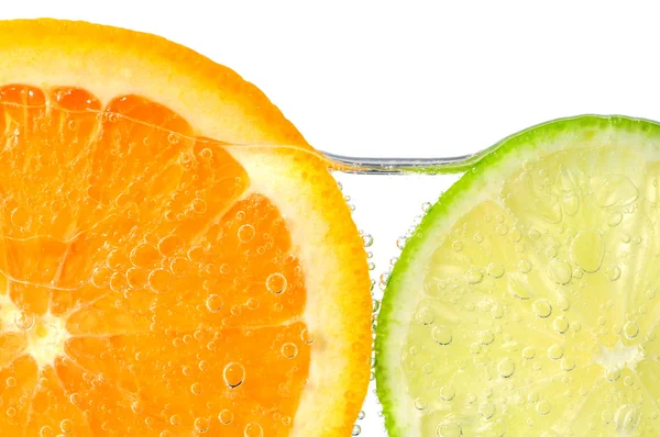 Fatias de laranja e limão na água — Fotografia de Stock