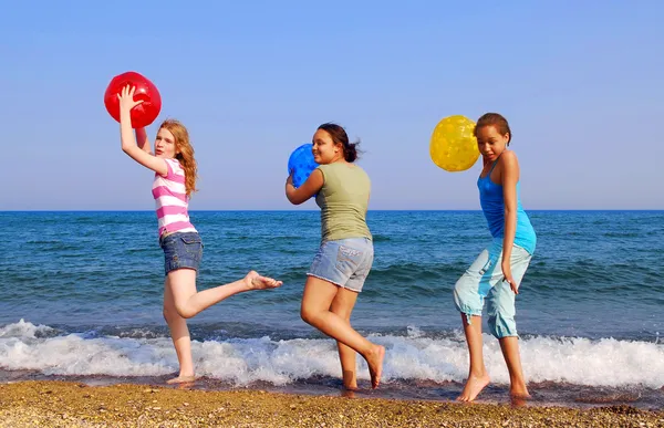 Trzy Dziewczyny Kolorowe Piłki Plażowe Spacery Nad Brzegiem Morza — Zdjęcie stockowe