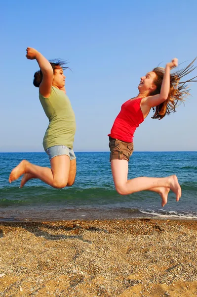 Dos Chicas Jóvenes Saltando Una Orilla Del Mar —  Fotos de Stock