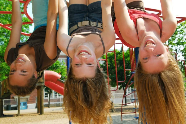 三个年轻女孩倒挂在公园和笑 — 图库照片