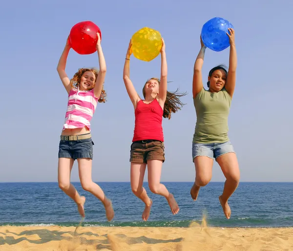 Três Meninas Uma Praia Areia Pulando Com Bolas Coloridas — Fotografia de Stock