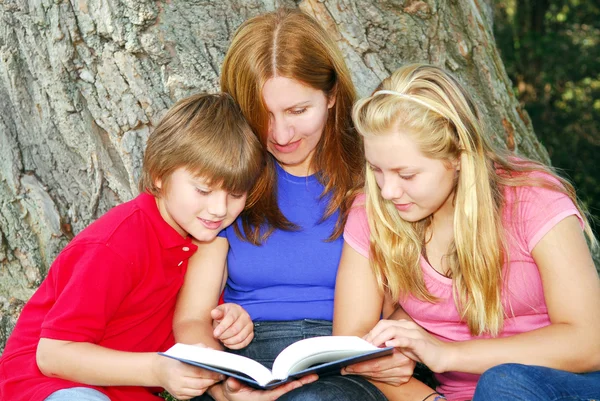 Familia leyendo un libro — Foto de Stock
