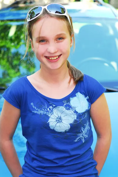 車のボンネットの上に座って微笑んでいる若い女の子の肖像画 — ストック写真