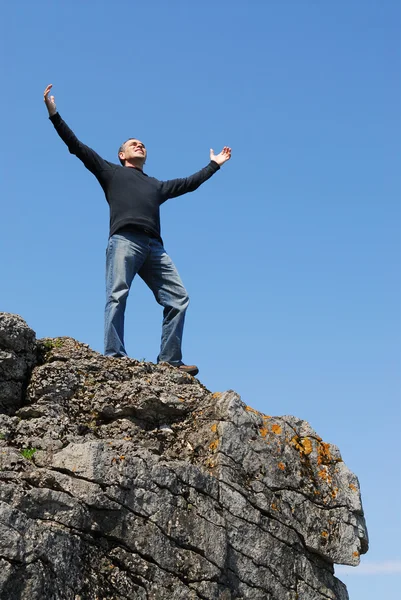 Człowiek Stojący Klifie Ręce Podniesione Błękitnego Nieba — Zdjęcie stockowe