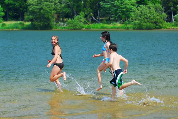 Niños corriendo hacia el agua —  Fotos de Stock