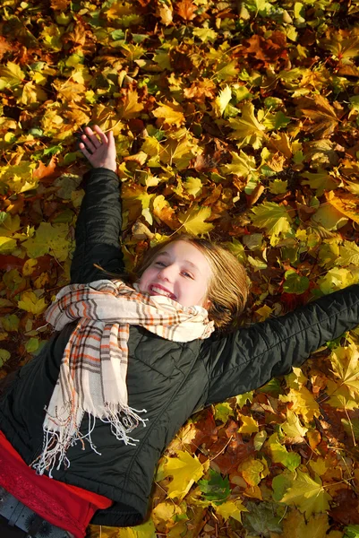 秋の公園で落とされた葉の上に横たわる美しい十代の少女 — ストック写真